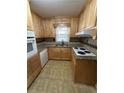 The cozy kitchen features classic wood cabinets, tiled floors, and durable countertops at 2977 Appling Dr, Atlanta, GA 30341