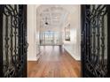 Elegant foyer with decorative iron doors, hardwood floors, and a view of the open living space at 490 Revenna Trl, Fayetteville, GA 30214