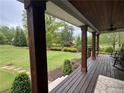 Covered porch offering a picturesque view of the landscaped front yard and gardens at 77 Russell Rd, Lawrenceville, GA 30043
