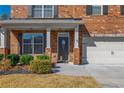 Welcoming front entrance with a decorative glass door, brick pillars, and lush landscaping, creating an inviting curb appeal at 6645 Country Lake Rd, Cumming, GA 30041