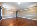 Spacious living room featuring gleaming hardwood floors, neutral wall colors, and modern lighting, creating a warm, inviting space at 6645 Country Lake Rd, Cumming, GA 30041