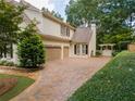 Long, paved driveway leads to a two-car garage, complemented by lush landscaping and a private gate at 1402 Downington Nw Vw, Acworth, GA 30101