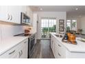 A kitchen featuring stainless steel appliances, white cabinets, and an island, leading to a view of the outside at 542 Sawnee Village Blvd # D69, Cumming, GA 30040