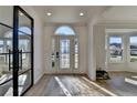 Bright foyer with a decorative glass front door, wood floors and modern black framed glass accent at 10683 Glenleigh Dr, Johns Creek, GA 30097