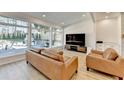 Inviting living room with large windows overlooking a patio and backyard, wood floors and TV at 10683 Glenleigh Dr, Johns Creek, GA 30097