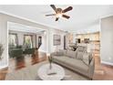 Bright living room boasts hardwood floors, neutral paint, open layout, and a ceiling fan at 160 Deer Cliff Cv, Lawrenceville, GA 30043