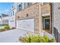 Close-up of garage and front door with brick exterior and manicured landscaping at 5711 Tillman Way, Powder Springs, GA 30127