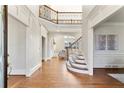 Bright foyer with hardwood floors, staircase, and views into other rooms at 1021 Windermere Xing, Cumming, GA 30041