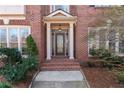 Elegant brick home entrance with a detailed, glass-paneled front door at 1021 Windermere Xing, Cumming, GA 30041