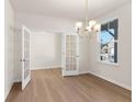 Bright dining room with wood floors, chandelier and open french doors with lots of natural light from the windows at 4793 Moonstone Trce, Kennesaw, GA 30144