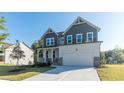 Two-story home featuring a two-car garage, stone accents, and a covered front porch, surrounded by a well-manicured lawn at 4793 Moonstone Trce, Kennesaw, GA 30144