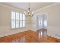 Bright dining room featuring plantation shutters, elegant chandelier, and hardwood floors at 305 Hembree Grove Trce, Roswell, GA 30076