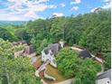 An expansive aerial view showing the home nestled in a lush, green, wooded area at 500 River Bluff Pkwy, Roswell, GA 30075