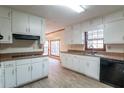 Functional kitchen with white cabinets, black appliances, and wood-look flooring at 895 Smoketree Dr, Tucker, GA 30084