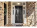 Inviting front door with decorative windows, a brick surround, and updated hardware at 142 Perimeter Walk, Atlanta, GA 30338