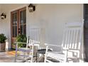 Inviting front porch with classic rocking chairs and a stylish wood front door, perfect for relaxing outdoors at 1285 Oakhaven Dr, Roswell, GA 30075