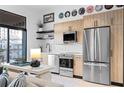 Modern kitchen with stainless steel appliances, wood cabinets, and views to the outdoor balcony at 567 Ponce De Leon Ne Ave # 317, Atlanta, GA 30308