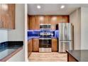 Well-equipped kitchen features wood cabinets, stainless steel appliances, and stylish dark backsplash at 361 17Th Nw St # 1021, Atlanta, GA 30363