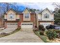 Townhome featuring a one-car garage, driveway, and landscaping in front at 875 Edgewater Cir, Marietta, GA 30062