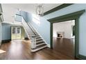 Spacious foyer with staircase, hardwood floors, elegant lighting, and view into the living room at 3051 Habersham Nw Rd, Atlanta, GA 30305