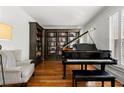 Elegant room with a grand piano, bookshelves, and a comfortable armchair at 730 Glenferry Trl, Atlanta, GA 30328