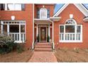 Charming brick home entrance with beautiful architectural details, steps, and well-maintained landscaping at 426 Lakestone Dr, Suwanee, GA 30024