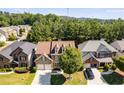 Aerial view of a two-story home with a brown roof, a two-car garage, and mature trees in the neighborhood at 730 Pear Grove Pl, Marietta, GA 30066