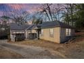 Side-rear view of a quaint home with a stone foundation and an adjacent driveway at 1815 Monroe Ne Dr, Atlanta, GA 30324