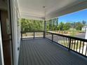 Covered porch with wood flooring, railing and a view of the trees and community at 1923 Cassia Aly, Kennesaw, GA 30144