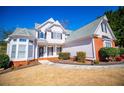 Charming two-story home featuring a manicured lawn, brick accents, and decorative shutters under a bright blue sky at 2003 Hubbard Ct, Villa Rica, GA 30180