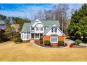 Two-story home featuring lush landscaping, a manicured lawn, brick accents, and decorative shutters on a sunny day at 2003 Hubbard Ct, Villa Rica, GA 30180