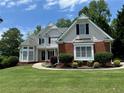 Charming two-story home features a well-manicured lawn and inviting curb appeal with black shutters at 2003 Hubbard Ct, Villa Rica, GA 30180