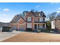Beautiful two-story brick home with a covered front porch, a two-car garage and well-kept landscaping at 325 Morning Mist Walk, Suwanee, GA 30024