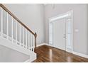 Entryway with hardwood floors, a white front door, and staircase with stained wood railing at 1168 Christiana Xing, Lawrenceville, GA 30043