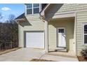 Charming two-story home with a light green exterior, front door, and a neatly attached single-car garage at 3185 Tackett Rd, Douglasville, GA 30135