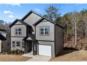 Stylish two-story home with a single car garage, gray siding, black trim, and a well-maintained lawn at 3195 Tackett Rd, Douglasville, GA 30135