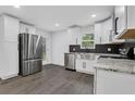 Bright kitchen featuring stainless steel appliances, granite countertops, and stylish white cabinetry at 3850 Crosby Nw Dr, Atlanta, GA 30331