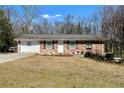Inviting brick home with attached garage, complemented by a spacious front yard and cozy landscaping at 147 Windy Hill Sw Rd, Marietta, GA 30060