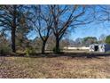 Spacious backyard with mature trees and a storage shed, perfect for outdoor activities at 3894 Summit Dr, Douglasville, GA 30135