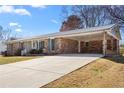 Lovely single-story brick home featuring a metal roof, covered carport, and a spacious concrete driveway at 3894 Summit Dr, Douglasville, GA 30135