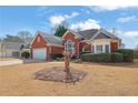 Charming red brick home features an attached two-car garage and mature landscaping at 4198 Haynes Mill Nw Ct, Kennesaw, GA 30144