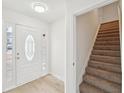 Bright entryway with a decorative glass front door, light wood flooring, and staircase leading upstairs at 10 Dairyland Dr, Covington, GA 30016