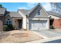 Charming townhome with a two-car garage, tan brick facade, and well-maintained landscaping at 3832 Abbott Ln # 1, Powder Springs, GA 30127