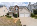 Two-story home featuring stone accents, vinyl siding, a two-car garage, and a cozy front porch at 4728 Sedum Way, Atlanta, GA 30349