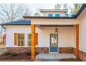 Covered front porch featuring stacked stone, wood columns, a blue door, and a hanging lantern at 30 Sportsman Path, Dallas, GA 30157
