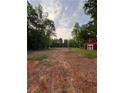 View of cleared property with a red barn and trees surrounding the perimeter at 30 Sportsman Path, Dallas, GA 30157