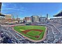 Panoramic aerial view of a modern baseball stadium with fans, city skyline in the background under a bright sky at 2428 Crescent Park Ct, Atlanta, GA 30339