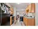 Functional kitchen with wood cabinetry and modern black appliances at 6327 Ellenwood Dr, Rex, GA 30273