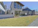 Contemporary two-story home featuring large windows, sleek design, and well-manicured lawn at 115 Arcadia Ave, Fayetteville, GA 30214