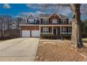 Beautiful brick two-story home with a cozy front porch and well-manicured landscaping at 2124 Mitford Ct, Dacula, GA 30019